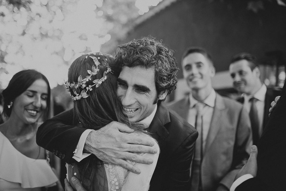 Emotional embrace shared during black and white wedding celebration photo.