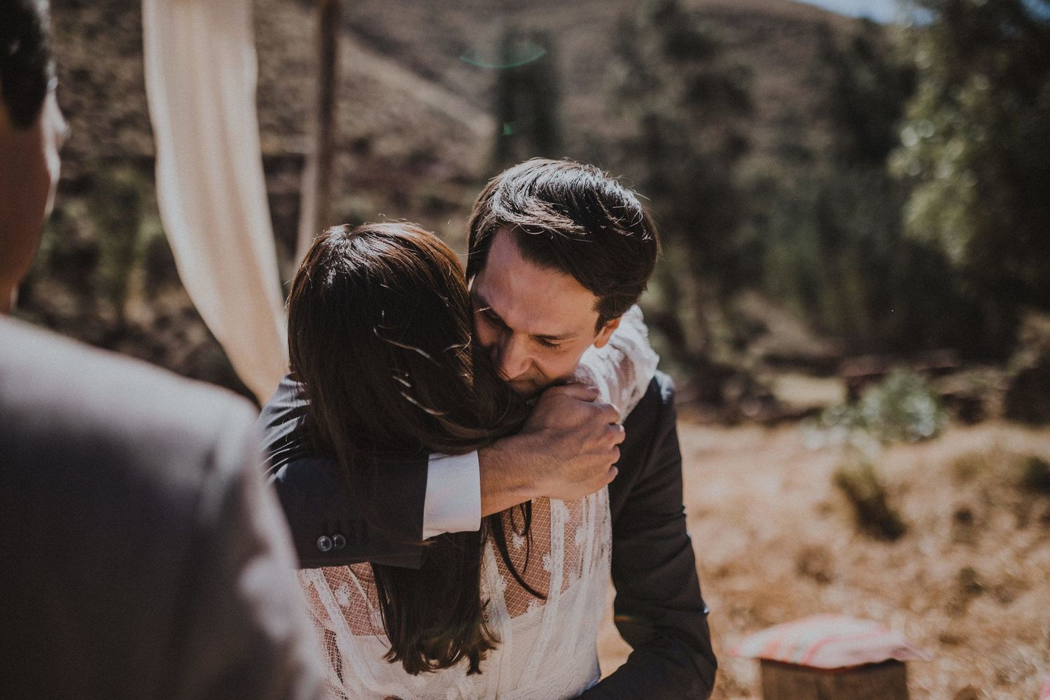 A tender embrace shared during an outdoor desert wedding ceremony.