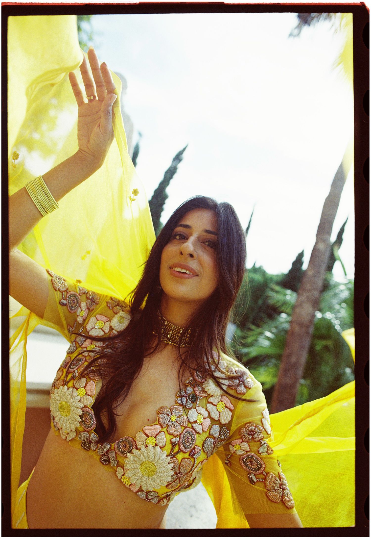 Film portrait of Elina lifting yellow fabric above her head.