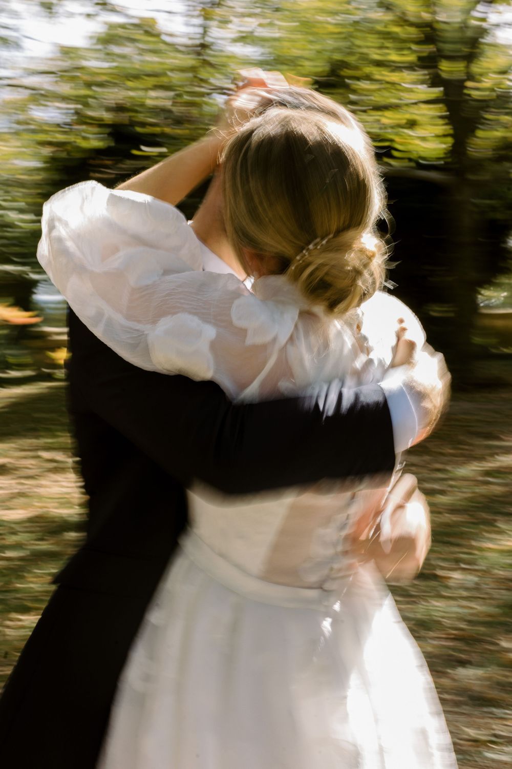 Motion-blur wedding photos capturing couple embracing in natural setting.