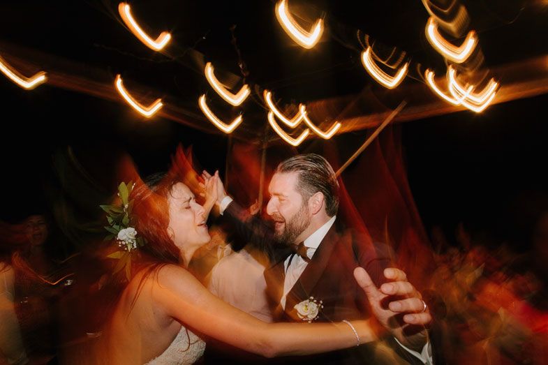 Dancing couple at a wedding reception with blurred light trails creating a dreamy atmosphere.