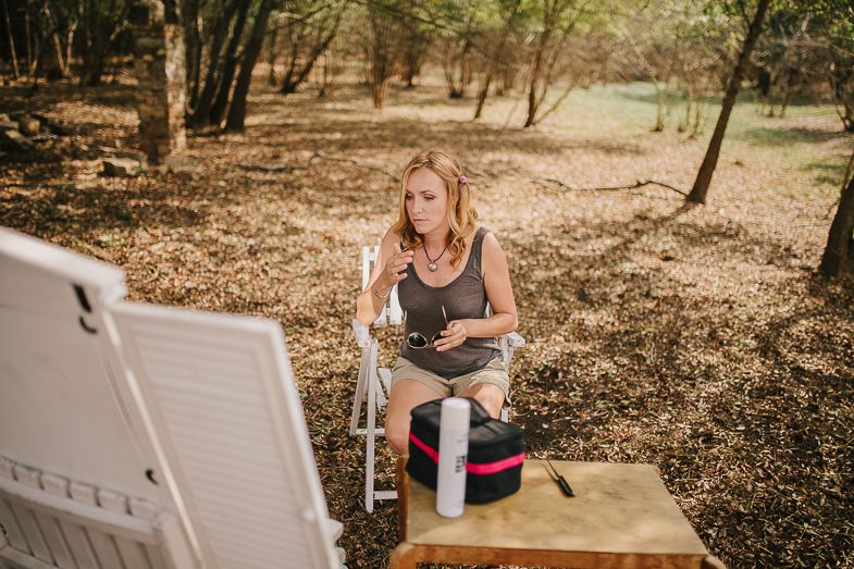 A peaceful outdoor scene with someone seated in a wooded area getting ready.