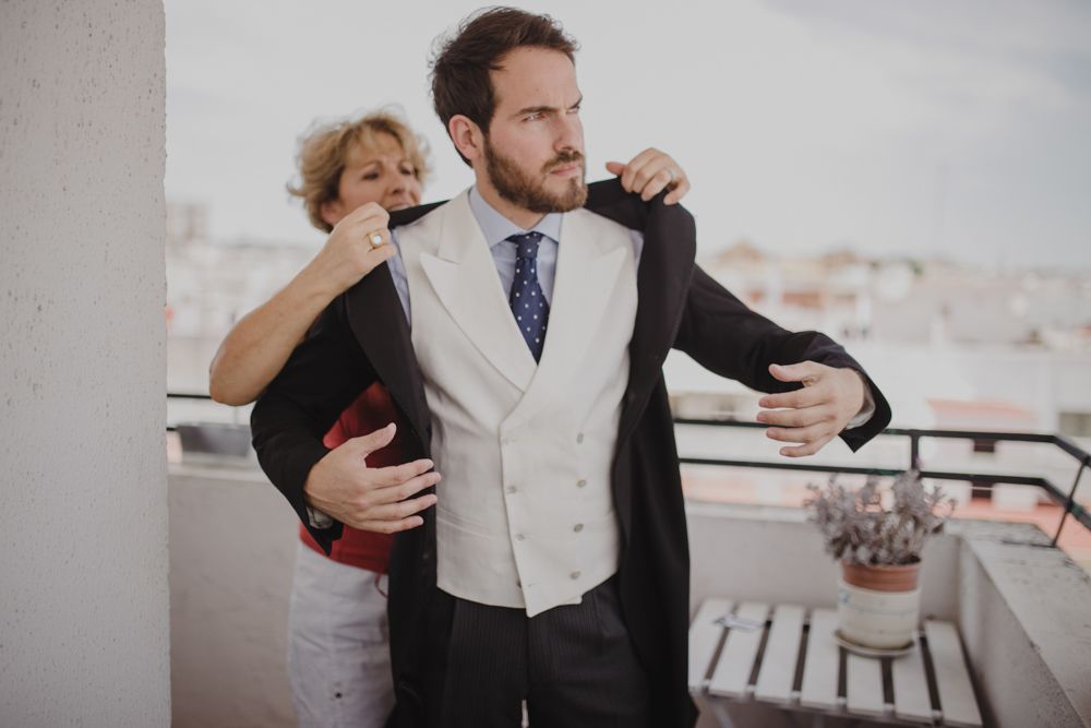 Wedding preparations on a sunny balcony with city views in background.