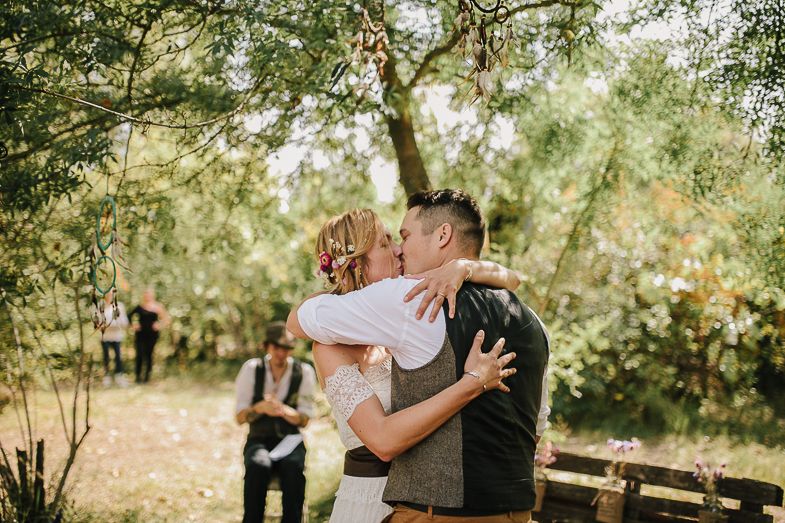 A tender moment shared between newlyweds during their outdoor forest wedding ceremony.