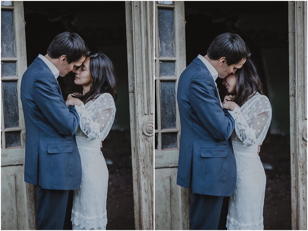A romantic couple in wedding attire sharing an intimate embrace in a vintage doorway.