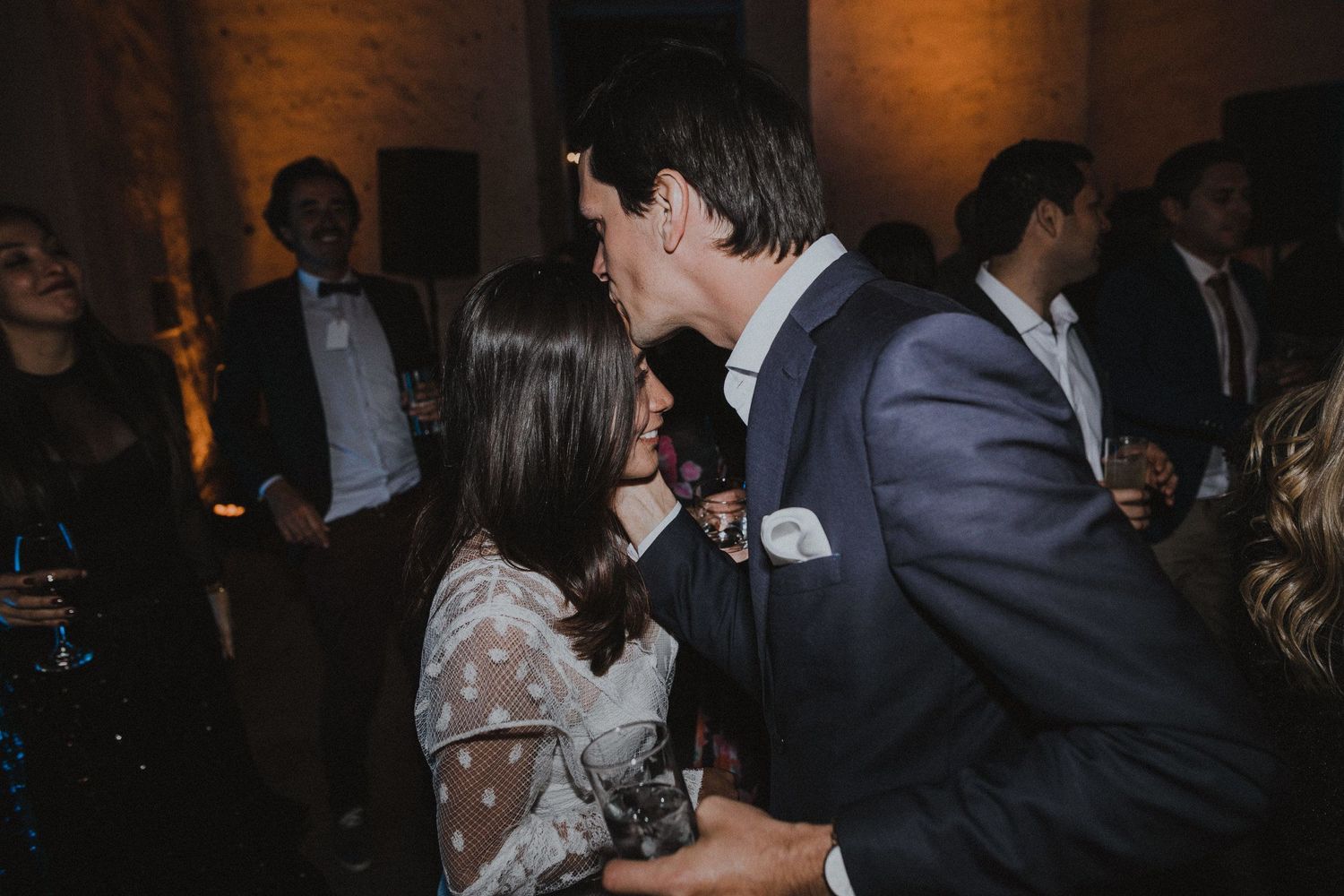 Couple sharing an intimate dance moment at an indoor celebration.