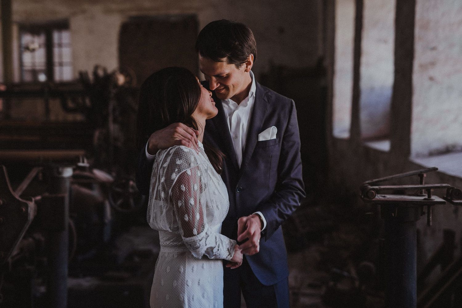 An intimate wedding moment captured in moody indoor lighting with vintage decor.