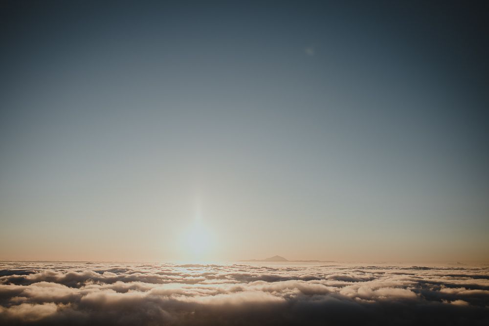 Stunning sunrise over a sea of clouds with golden light breaking through.
