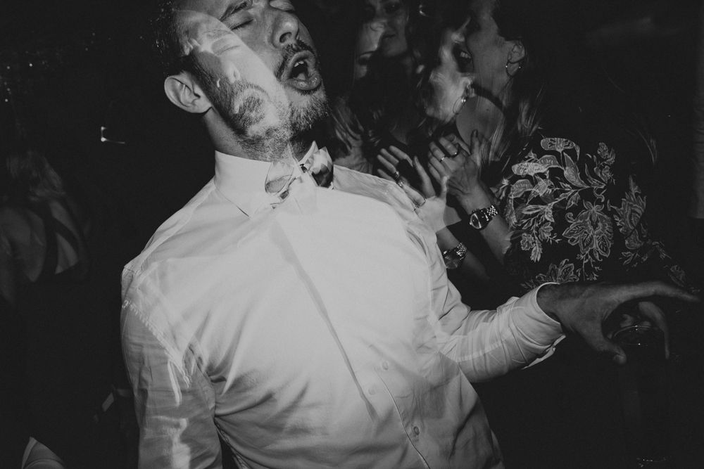 Energetic dancers captured in black and white during an animated party moment.