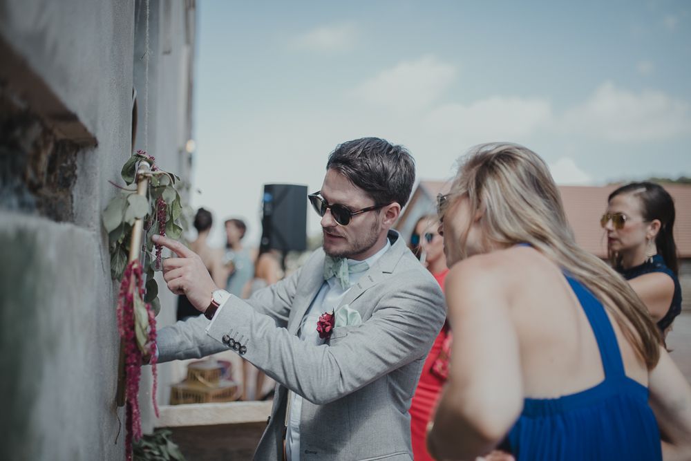 Wedding guests looking at their phones during an outdoor celebration.