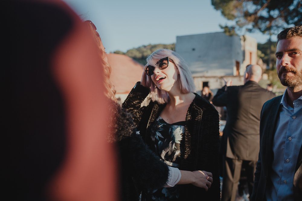 Wedding guests enjoying an outdoor reception on a sunny day.