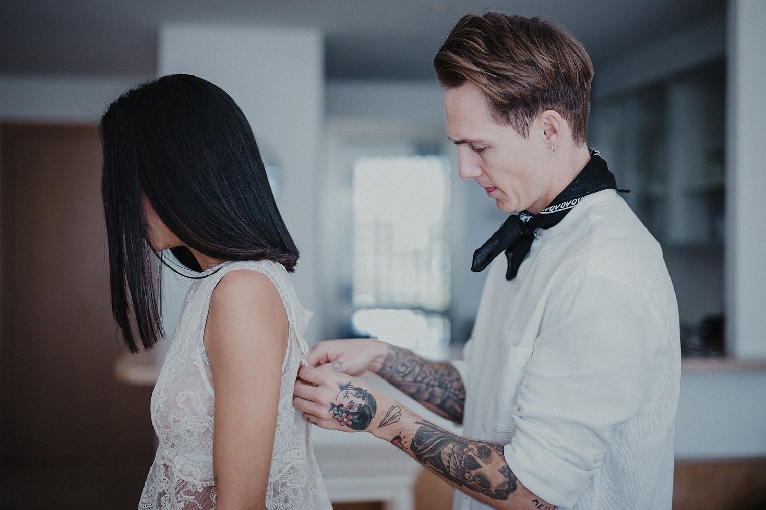 Elegant couple in formal attire sharing an intimate moment in soft lighting.