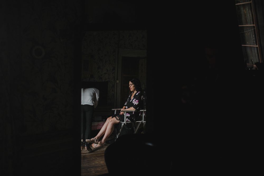 Silhouette of someone sitting in a dimly lit room with vintage furniture.