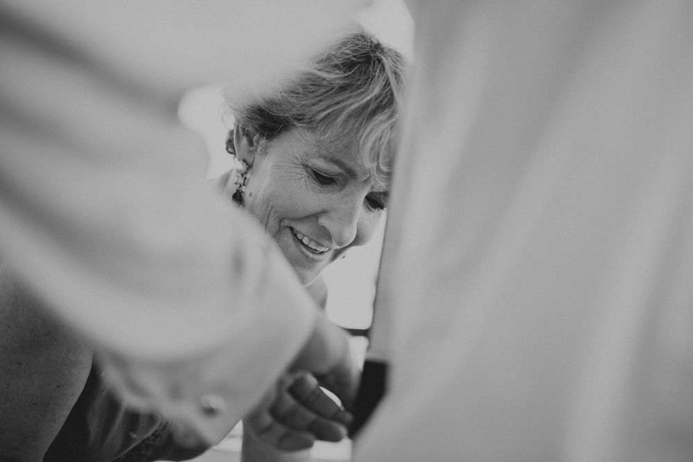 Black and white candid moment captured through curtains.