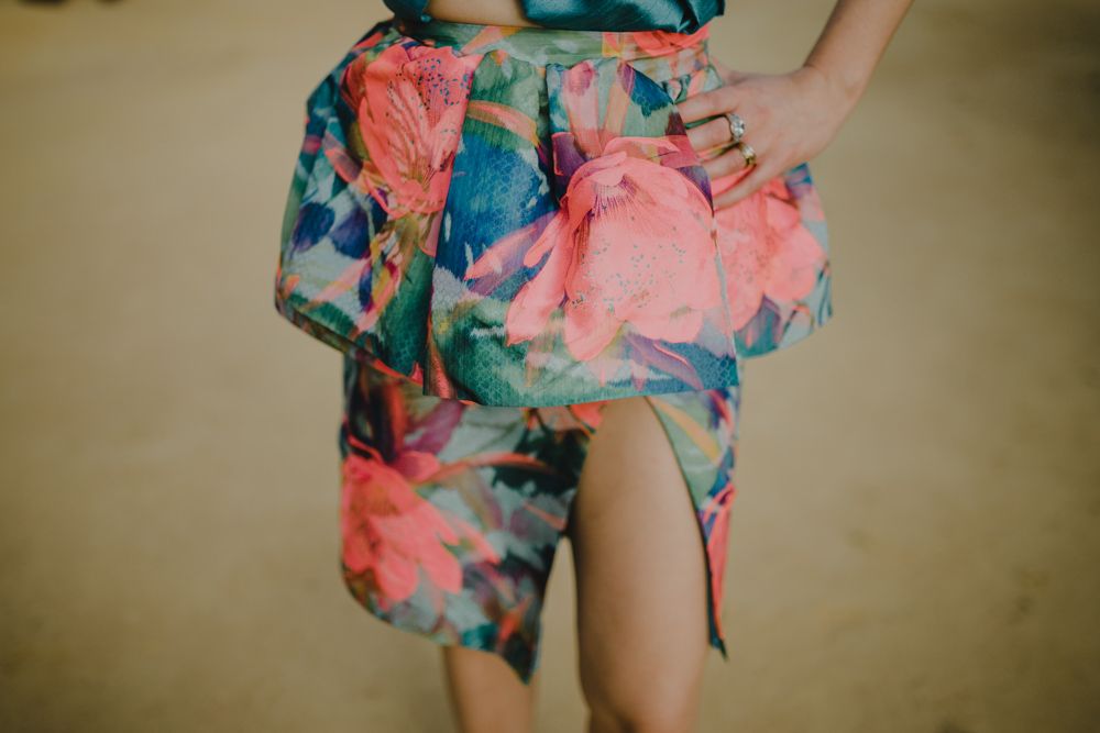 Close-up detail of a floral print dress with coral and blue watercolor pattern.