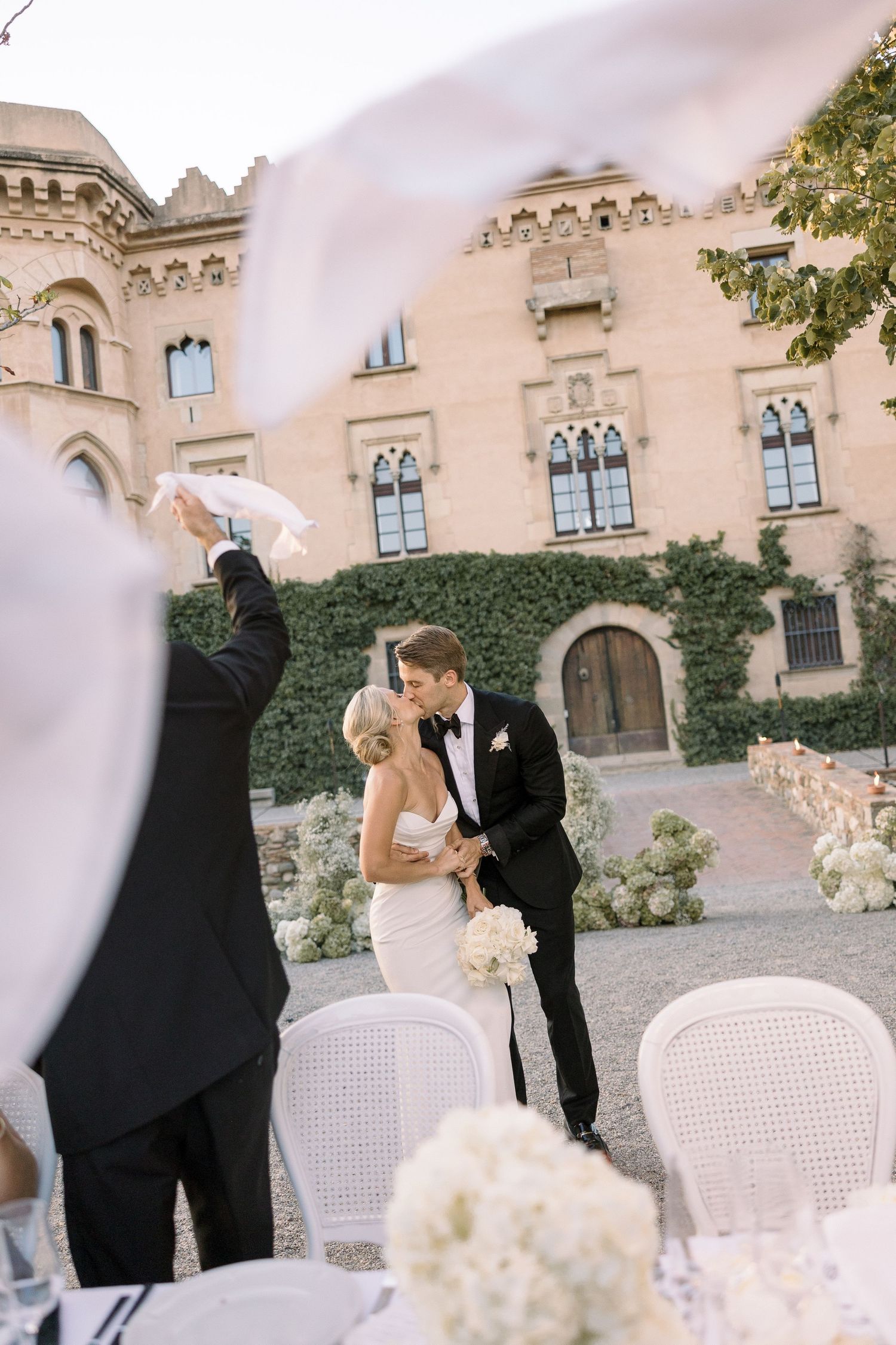 Romantic wedding moment captured at elegant castle venue with white floral decorations.