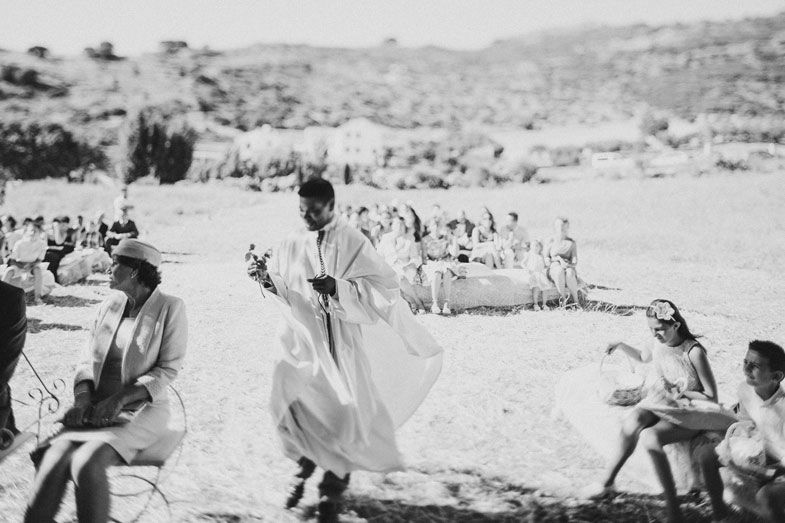 A vintage black and white photo of a wedding celebration in an outdoor setting.