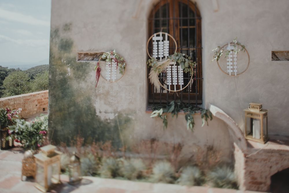 Rustic Mediterranean style window with decorative ironwork and climbing plants.