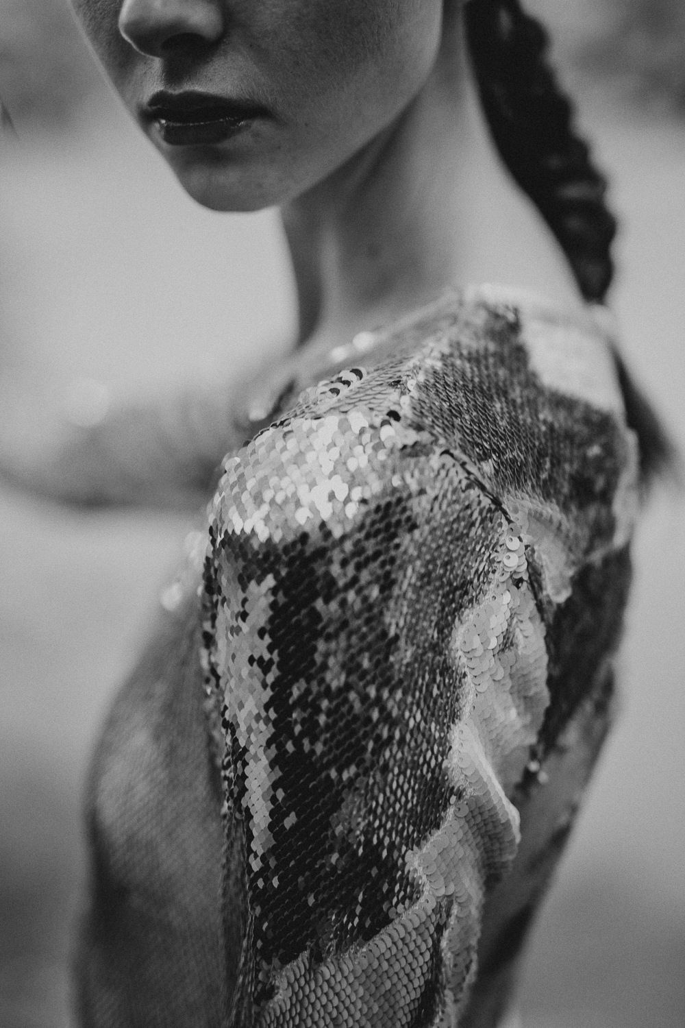Black and white detail of textured sequin dress shoulder.