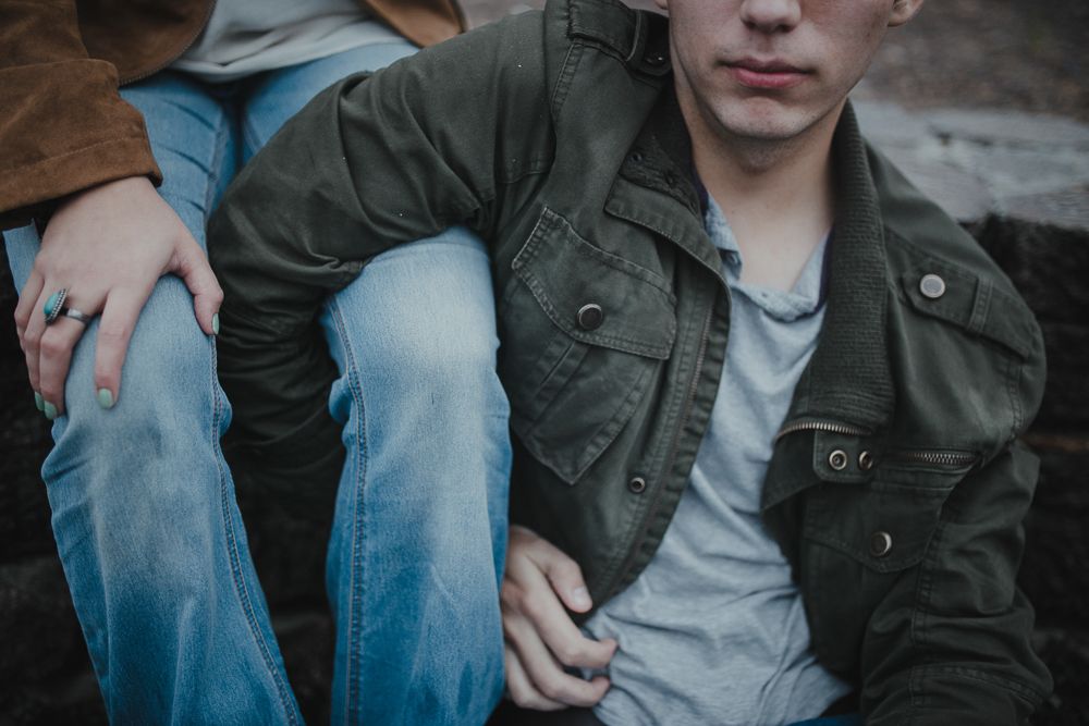 Close-up of casual attire showing denim jeans and army green jacket details.
