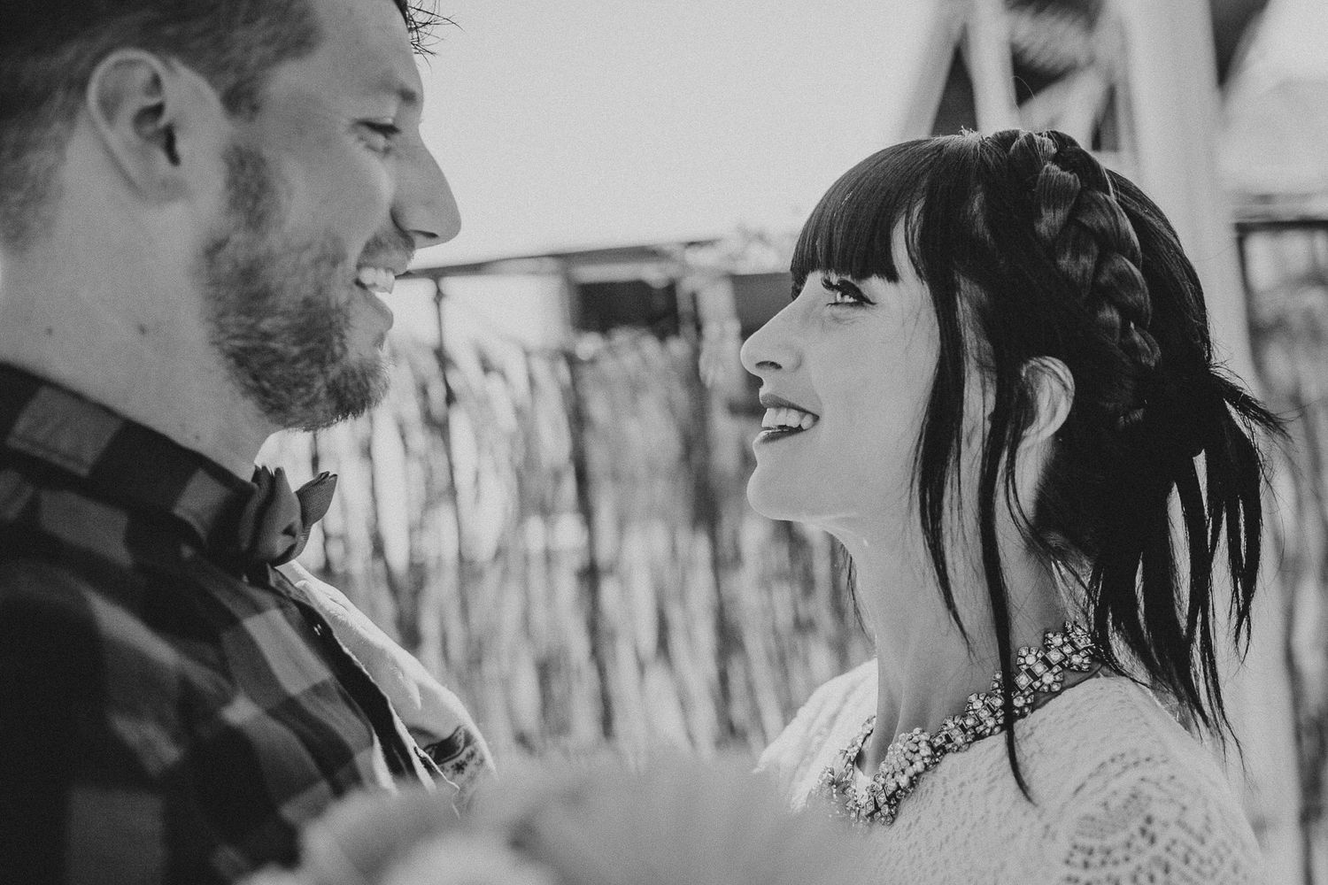 Black and white photo capturing intimate moment between couple outdoors.
