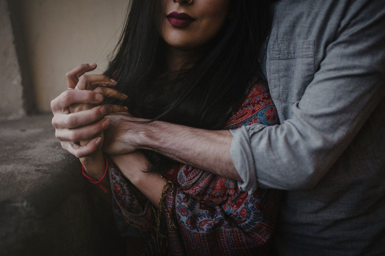 Close up of couple's hands embracing in romantic moment.