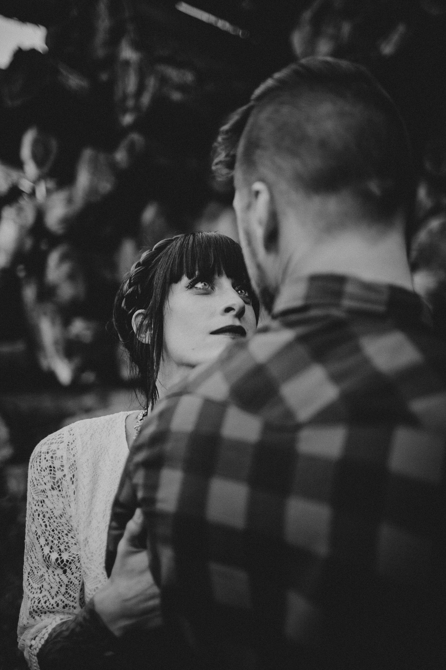Artistic black and white portrait capturing a tender moment between two people.