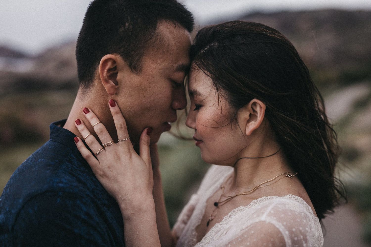 Intimate portrait of couple sharing tender moment in natural setting.