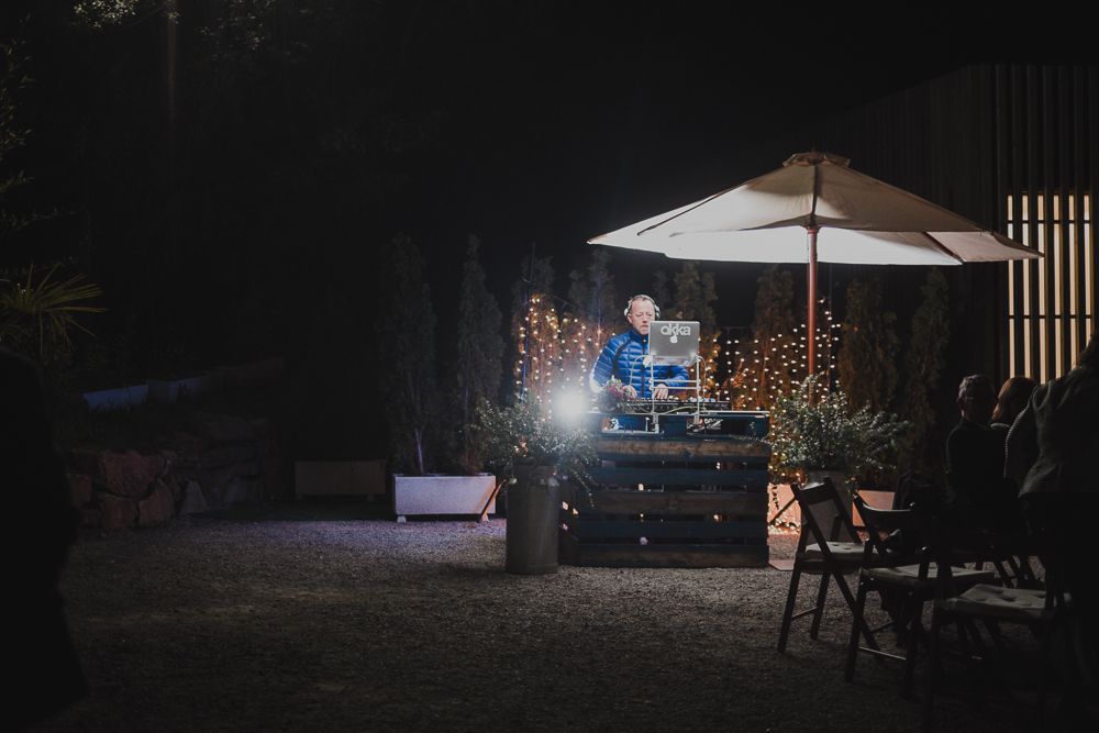 An outdoor nighttime party setup with string lights and a white umbrella creating an ambient atmosphere.