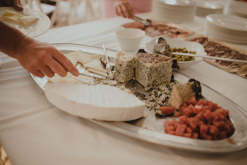 A white platter with various snacks including berries and what appears to be a textured dip or spread being served.
