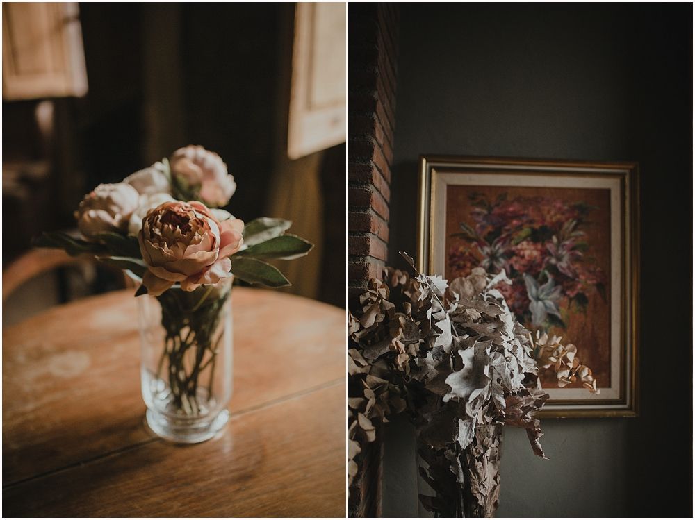 Still life diptych of dried roses in vase and framed floral artwork in moody lighting.
