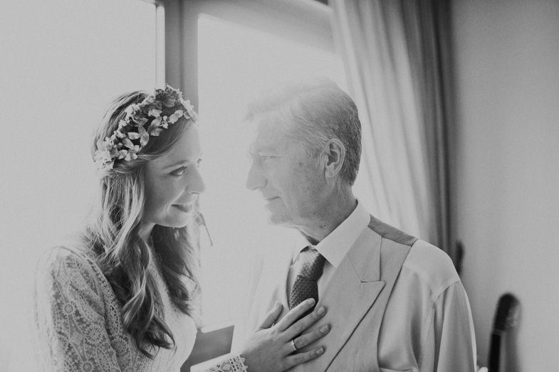 Intimate black and white moment between bride in floral crown and loved one.