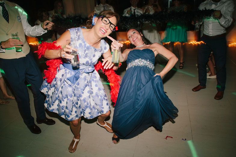 Wedding guests dancing and celebrating in festive party dresses.