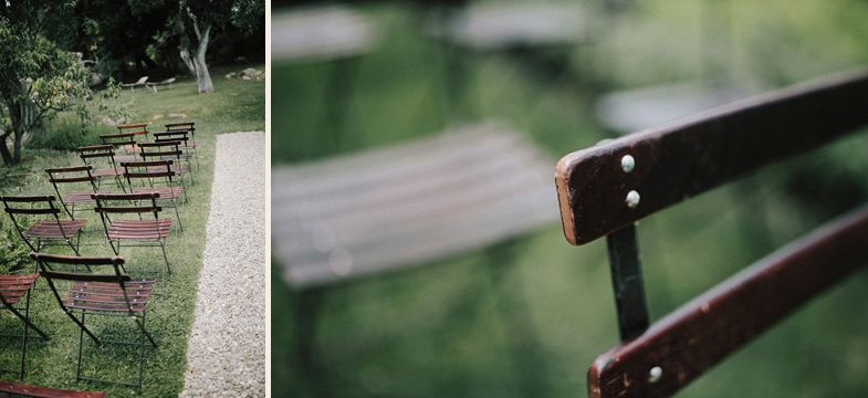 Empty wooden chairs lined up outdoors for wedding ceremony with detail of chair back.