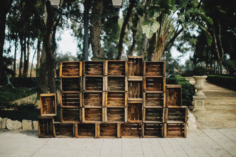 Rustic wooden crates stacked against wall creating shelving display outdoors.
