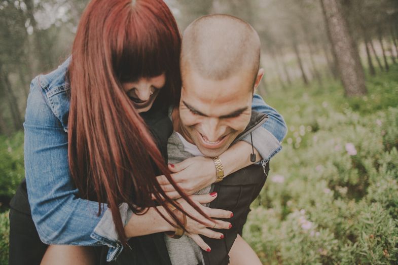 A couple sharing an intimate embrace in a natural outdoor setting.