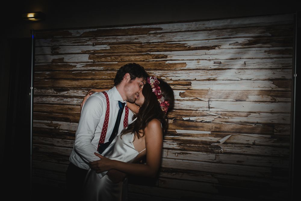 Romantic moment between couple against rustic wooden wall background.
