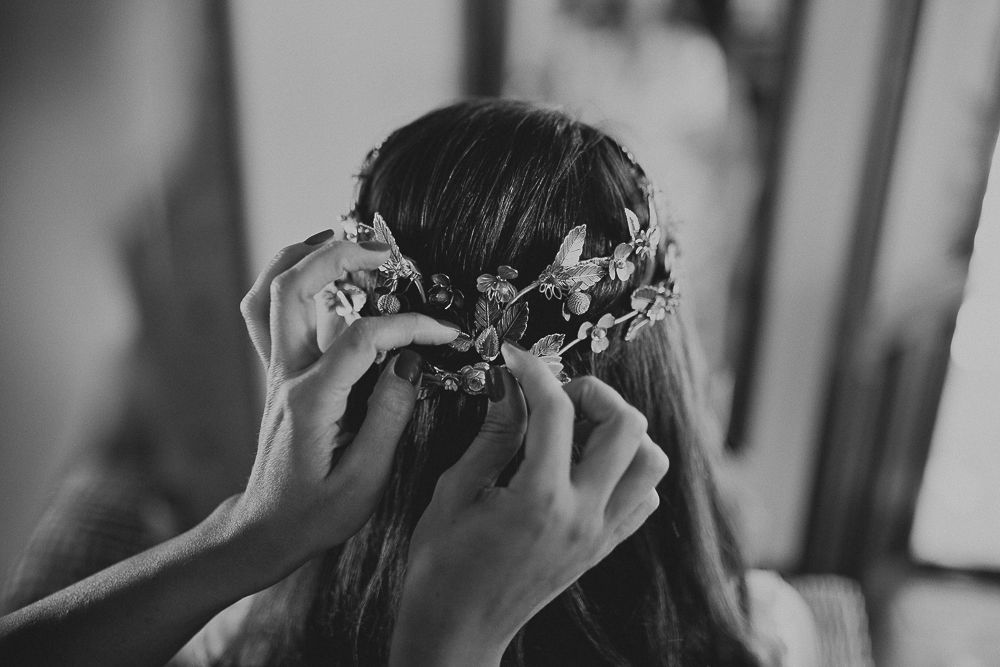 Close-up black and white shot of hands adjusting a floral hair accessory.