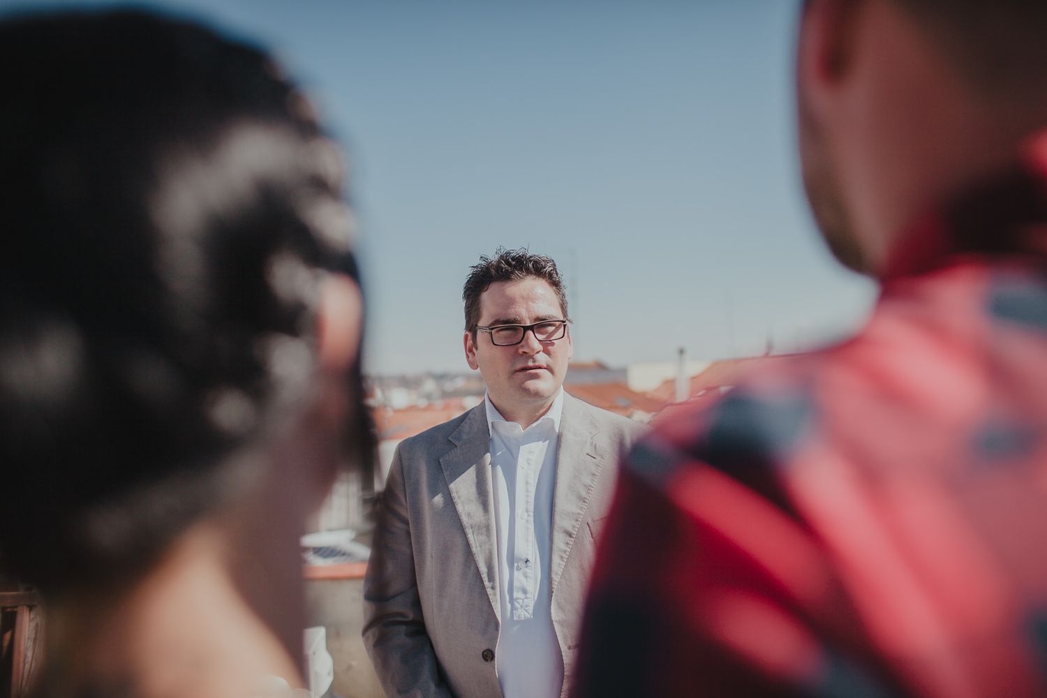 A ceremony taking place on a rooftop with terracotta buildings visible in the background.
