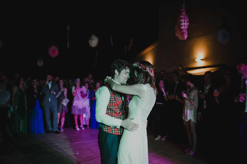 Couple dancing under purple and blue lighting at an indoor celebration.