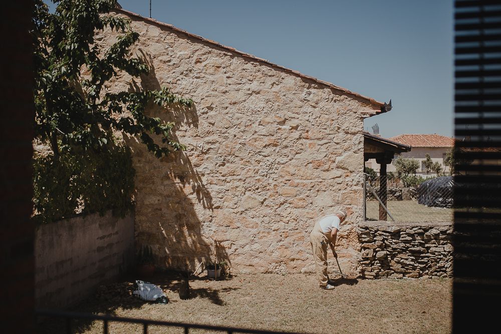 Rustic stone building exterior with whitewashed walls in bright sunlight.