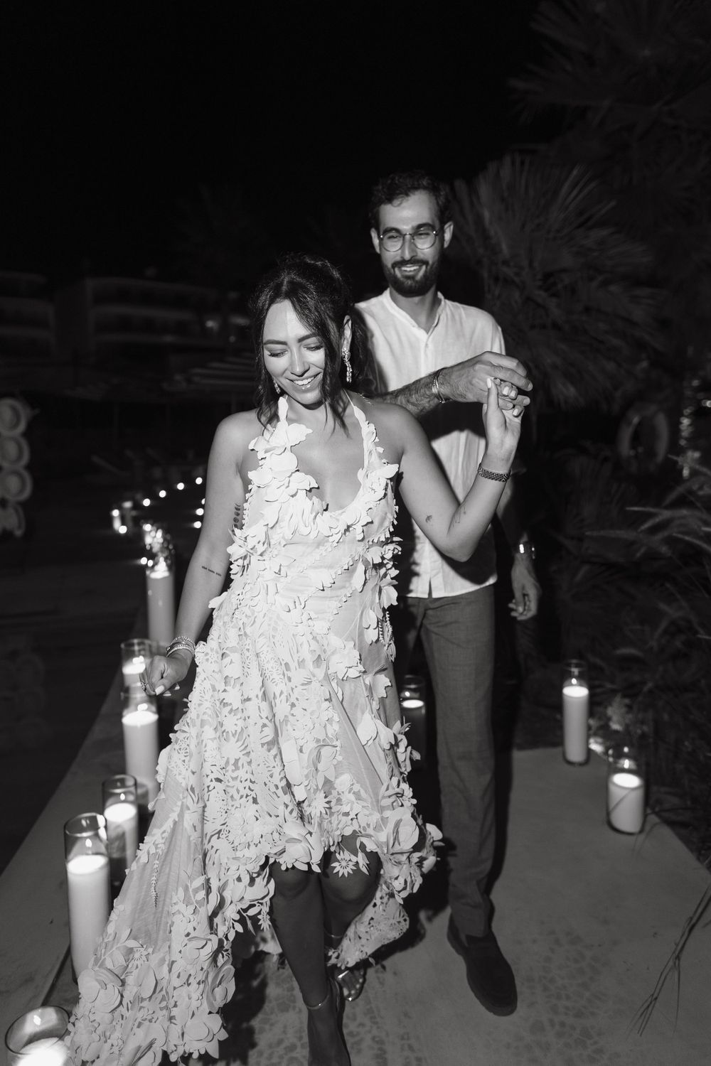 Nighttime celebration with guests in white attire dancing outdoors.