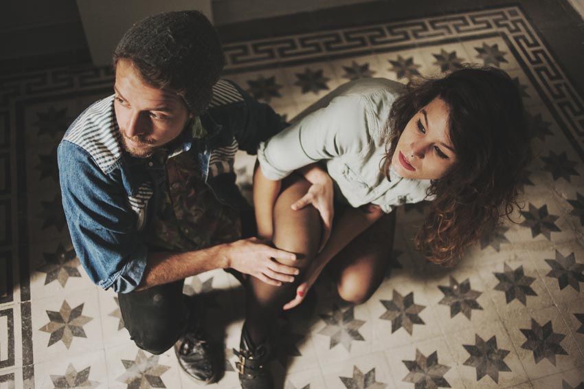 Two people sitting on patterned floor with geometric tile design.