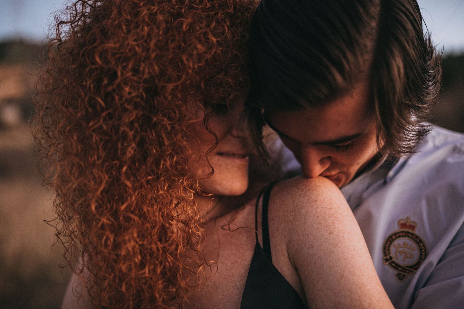 An intimate close-up portrait of a couple sharing a tender moment outdoors.