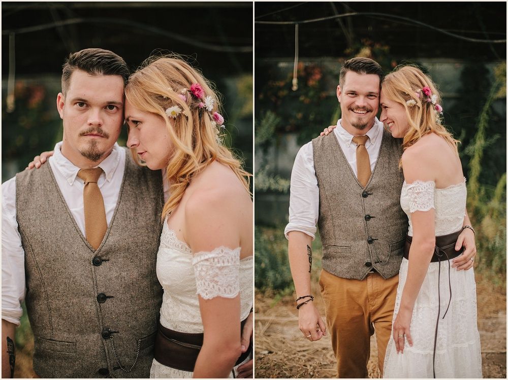 Romantic couple in rustic wedding attire standing in greenhouse setting.