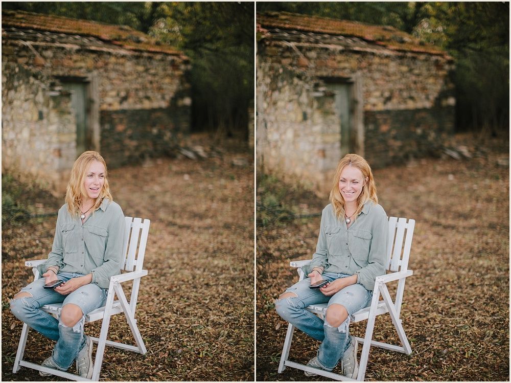 Casual portrait session with white wooden chair against stone wall backdrop.
