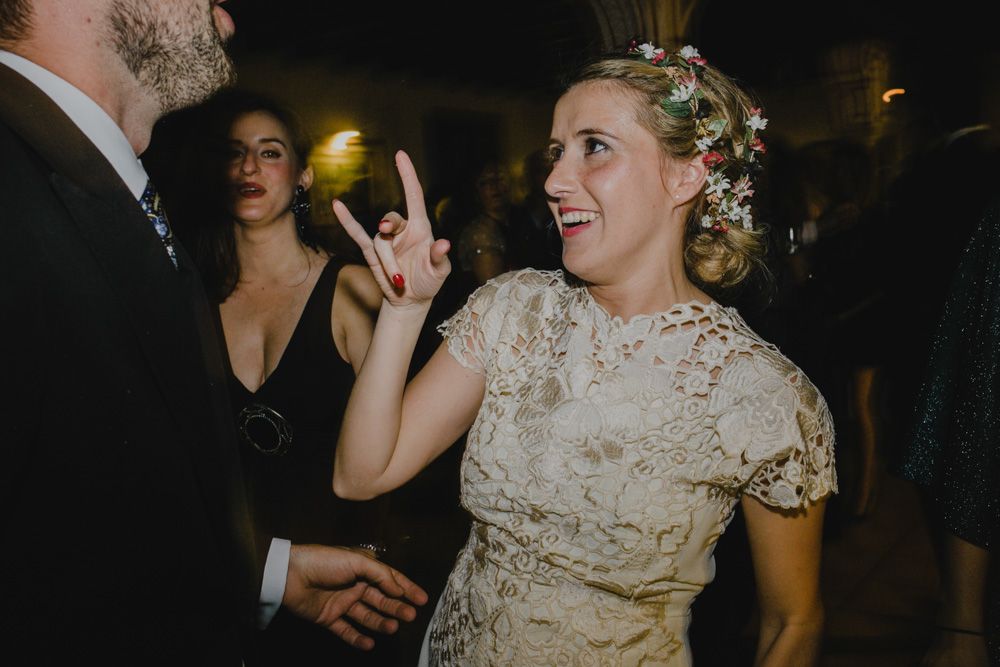A wedding celebration scene with guests dancing and socializing at an evening reception.