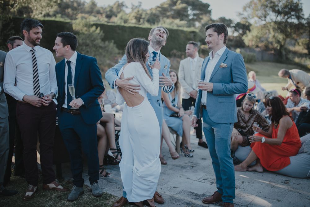 Wedding celebration on a hillside with guests dancing and mingling at sunset.