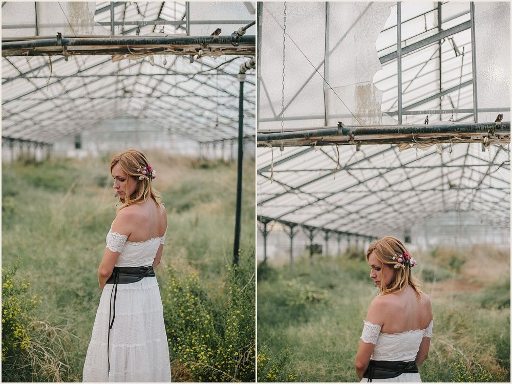 White off-shoulder dress with black sash photographed in a greenhouse setting.
