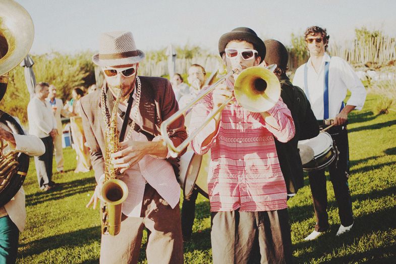 Festive brass band performing outdoors in vintage-inspired attire.